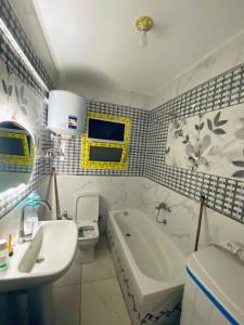 a bathroom with a tub and a sink and a toilet at بيت سعد in Hihyā