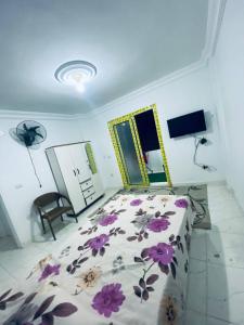 a bedroom with a bed with purple flowers on it at بيت سعد in Hihyā