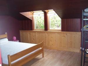 a bedroom with a bed and two windows at Villa ensoleillée à Saint Hilaire de Riez avec piscine privée in Saint-Hilaire-de-Riez