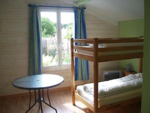 a room with two bunk beds and a table and a window at Villa ensoleillée à Saint Hilaire de Riez avec piscine privée in Saint-Hilaire-de-Riez +10 photos