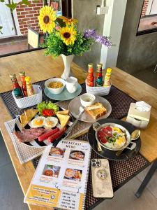 a breakfast table with breakfast foods and a vase of flowers at Baan Chiang Maan in Chiang Mai