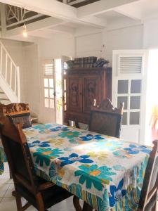 a dining room with a table with a flowered table cloth at Villa Enchantée avec Vue sur mer et Piscine au Carbet in Le Carbet