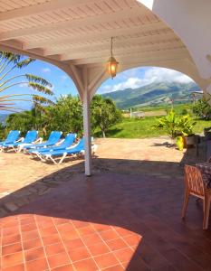 a group of lounge chairs under a pavilion at Villa Enchantée avec Vue sur mer et Piscine au Carbet in Le Carbet