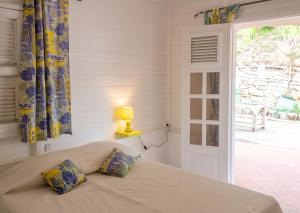 a bedroom with a bed with a lamp and a window at Villa Enchantée avec Vue sur mer et Piscine au Carbet in Le Carbet