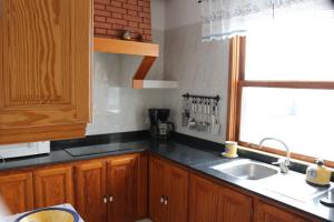 a kitchen with wooden cabinets and a sink and a window at Welcoming apartment with mountain view in El Paso