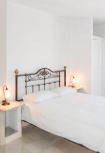 a bedroom with a white bed and two lamps at Charming House in Paros, 90 m² with Shared Pool in Parikia