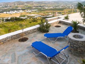 a patio with two blue chairs and a fire pit at Charming House in Paros, 90 m² with Shared Pool in Parikia +14 photos