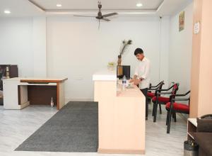 a man standing at a counter in an office at Fly Inn in Guwahati