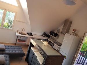 a small kitchen with a refrigerator and a table at Villa charmante à Saint-Benoît avec piscine privée in Saint-Benoît