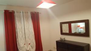 a bathroom with red curtains and a mirror at Villa charmante à Saint-Benoît avec piscine privée in Saint-Benoît