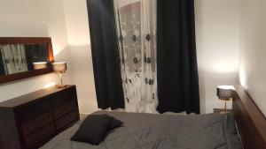 a bedroom with a bed with black curtains and a dresser at Villa charmante à Saint-Benoît avec piscine privée in Saint-Benoît +45 photos