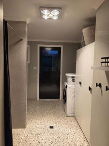 a kitchen with a black door and a stove at Tiatukia Beach House in North Shields +25 photos