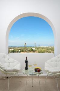 a room with two chairs and a table with wine glasses at Spacious Villa in Naxos with Sea View in Naxos Chora