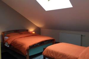 a attic bedroom with two beds and a skylight at Appartement chaleureux à Gérardmer avec parking privé. in Gérardmer