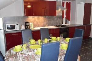 a kitchen with a table with yellow dishes on it at Appartement chaleureux à Gérardmer avec parking privé. in Gérardmer