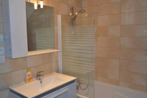 a bathroom with a sink and a shower with a mirror at Appartement chaleureux à Gérardmer avec parking privé. in Gérardmer
