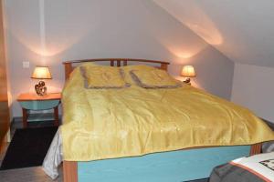 a bedroom with a bed with a yellow comforter at Appartement chaleureux à Gérardmer avec parking privé. in Gérardmer +61 photos