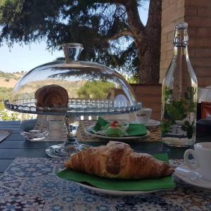 a table with a plate of croissants and a plate of bread at Beautiful Villa in Caccamo + Pool in Caccamo
