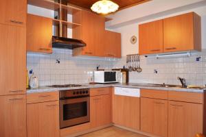 a kitchen with wooden cabinets and a microwave at Charming House in Pruggern, Mountain View in Pruggern