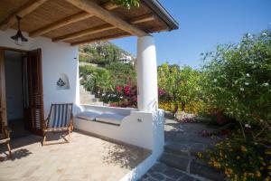 a porch of a house with a bench and flowers at Charming House in Lipari with Sea View in Lipari