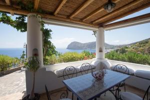 a table on a balcony with a view of the ocean at Charming House in Lipari with Sea View in Lipari