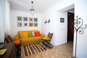 a living room with a couch with colorful pillows at Charming House in Lipari with Sea View in Lipari +15 photos