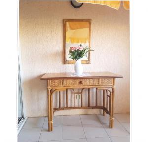 a vase of flowers on a table with a mirror at Appartement convivial à Gassin 37 m² avec vue sur la mer in Gassin