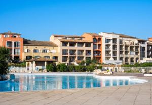 a large swimming pool with buildings in the background at Appartement convivial à Gassin 37 m² avec vue sur la mer in Gassin