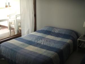 a blue and white bed in a room with a window at Charming Apartment in Troia, Garden View, 60 sqm in Troia