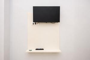 a flat screen tv on a white wall at Fly Inn in Guwahati