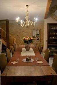 a dining room with a wooden table and a chandelier at Maison spacieuse à Cabariot in Cabariot