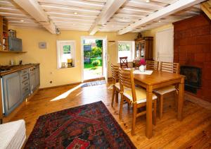 a dining room with a table and a kitchen at Authentic Fisherman House in Preila