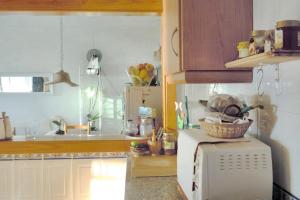a kitchen with a white microwave and a sink at Charming house with sea and mountain views in El Chaparral in EL Chaparral