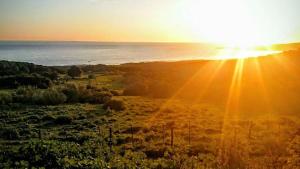 a sunset over the ocean with the sun setting at Charming house with sea and mountain views in El Chaparral in EL Chaparral