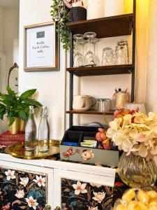 a shelf filled with dishes and other items in a kitchen at The Wadham in Weymouth