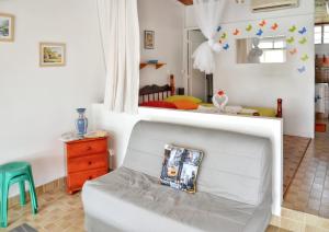 a living room with a white couch and a bedroom at Studio cocooning à Saint Anne / 27 m² / jardin fleuri in Sainte-Anne