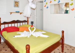 two swans sitting on a bed in a bedroom at Studio cocooning à Saint Anne / 27 m² / jardin fleuri in Sainte-Anne