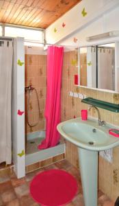 a bathroom with a sink and a pink shower curtain at Studio cocooning à Saint Anne / 27 m² / jardin fleuri in Sainte-Anne +12 photos
