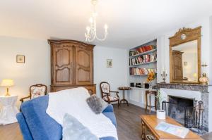 a living room with a blue couch and a fireplace at Les loulous in Arrentières