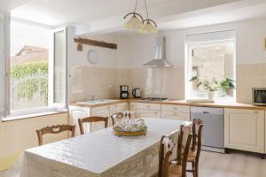 a kitchen with a white table and chairs and a window at Les loulous in Arrentières