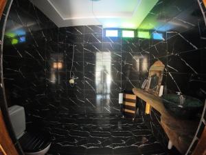 a bathroom with a black tiled wall with a sink at Ourika Atlas Tigmi in Ourika +80 photos