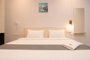 a white bed with white sheets and pillows at Fly Inn in Guwahati +39 photos