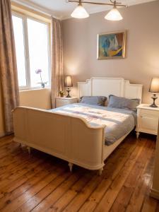 a bedroom with a white bed and two windows at Spacious House in Central Sofia with Garden in Sofia