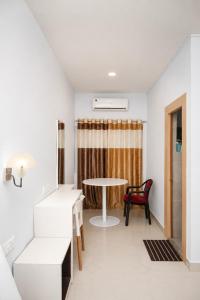a living room with a table and a chair at Fly Inn in Guwahati