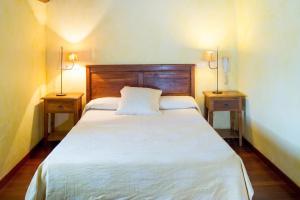 a bedroom with a white bed with two night stands at Luxurious Villa in Outeiro - Private Pool in Santa María La Mayor del Rosario