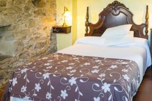a bedroom with a bed with a brown and white comforter at Luxurious Villa in Outeiro - Private Pool in Santa María La Mayor del Rosario