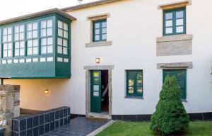 a white house with green doors and windows at Luxurious Villa in Outeiro - Private Pool in Santa María La Mayor del Rosario +22 photos
