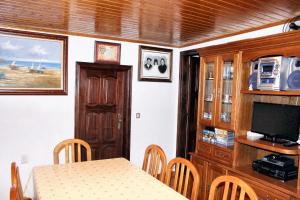 a dining room with a table and a television at Charming House in Paredes do Rio with Mountain View in Paredes do Rio