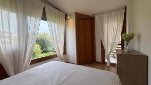 a bedroom with a bed and a large window at AP TXALUPA II in Barro de Llanes