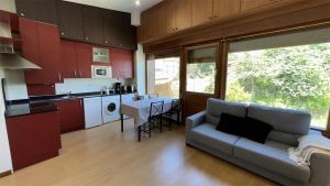 a living room with a couch and a kitchen at AP TXALUPA II in Barro de Llanes